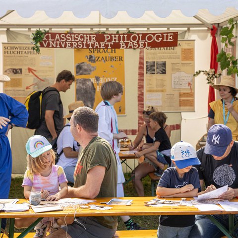 Fluchtäfelchen-oder-Schutzamulette-am-Stand-des-Departements-Altertumswissenschaften-der-Universität-Basel.jpg. Vergrösserte Ansicht