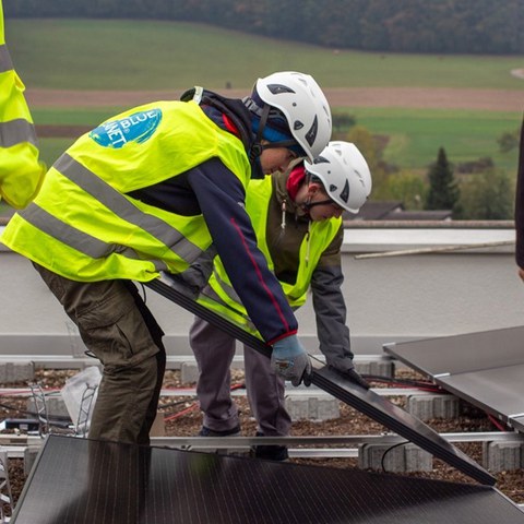 Am «Impact Day Energie» am 18. Oktober 2023 dürfen zwölf Schülerinnen und Schüler dem Montageteam der CKW tatkräftig zur Hand gehen und bei der Verlegung sowie Verkabelung der Solarmodule auf dem Schulhausdach aktiv mithelfen. Foto: myblueplanet. Vergrösserte Ansicht