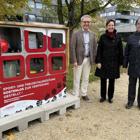 Gemeinderat Melchior Buchs, Regierungspräsidentin Monica Gschwind und Gemeinderat Markus Huber präsentieren die neue BoxUp-Station bei der Medienkonferenz in Reinach.. Vergrösserte Ansicht